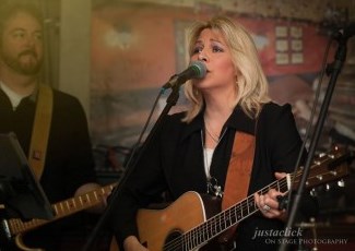 singer Wendy and Darren both playing guitars on stage