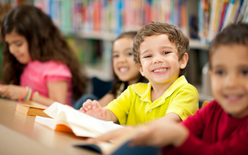 Children reading books inside a library