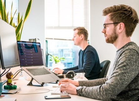 two men working on computer at office