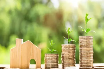 close up of toy wooden house and money